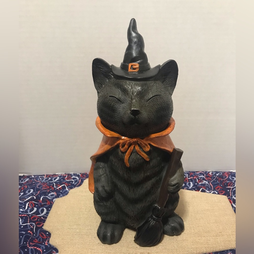 Halloween cat figurine with orange cape and broom